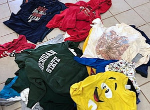 categories of T-shirts in piles on the floor for a T-shirt Quilt