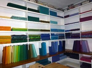 The best fabric for a T-shirt quilt is 100% cotton. This is a room full of the good stuff - fabric.