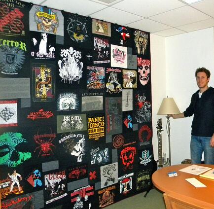 This concert T-shirt quilt hangs on the wall of a professional concert organizer.