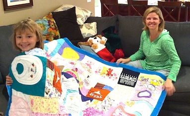 mom gets a baby clothes quilt made by Too Cool T-shirt Quilts