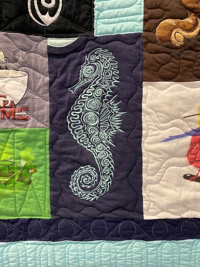 The front of a T-shirt quilt with a sea horse that has been traced.