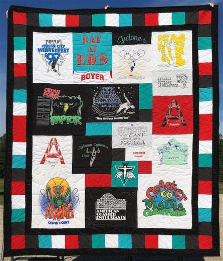 A T-shirt quilt with a triple border. Pieced + solid.