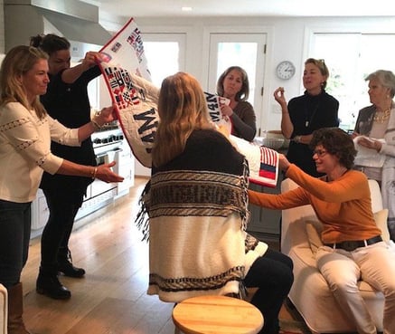 women opening a T-shirt quilt at a party